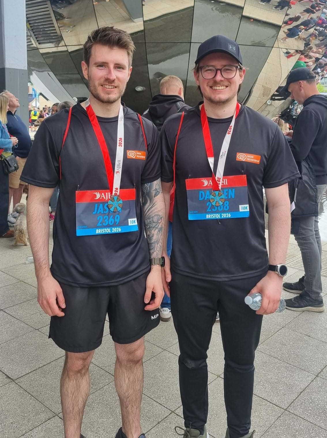 Photo of Darren and his brother Jason stood together after the 10k, wearing the finisher medals